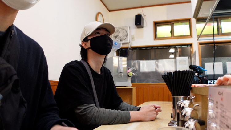 飲食店で取材する制作スタッフ