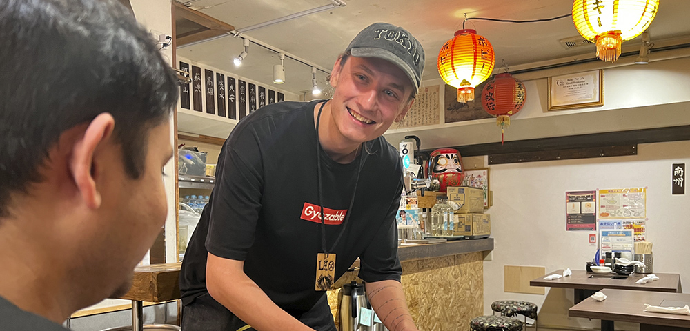 Experienced Gyoupao staff member coaching a colleague at the restaurant